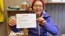 En av Misjonsutvalgets grand old ladies, Mette Waaler, holder frem en av de mange gevinstene MIsjonsutvalget har samlet inn til basar.