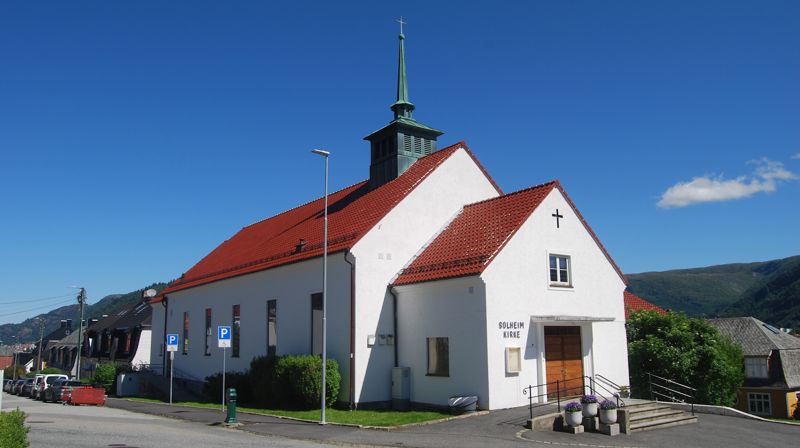 Solheim kirke en solfylt sommerdag, sett fra Hordagaten mot inngangsdøren