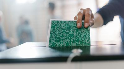 Stemmeseddel som blir puttet i urne