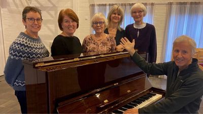 Lederteam : Marion Hammer, Tove Brekke, Aud Hatlevik, Mette Baarøy, Ellen Fasmer  Ved pianoet:  Dirigent Jan Tufteland.  Jan er utdannet musiker med fløyte som spesialitet.