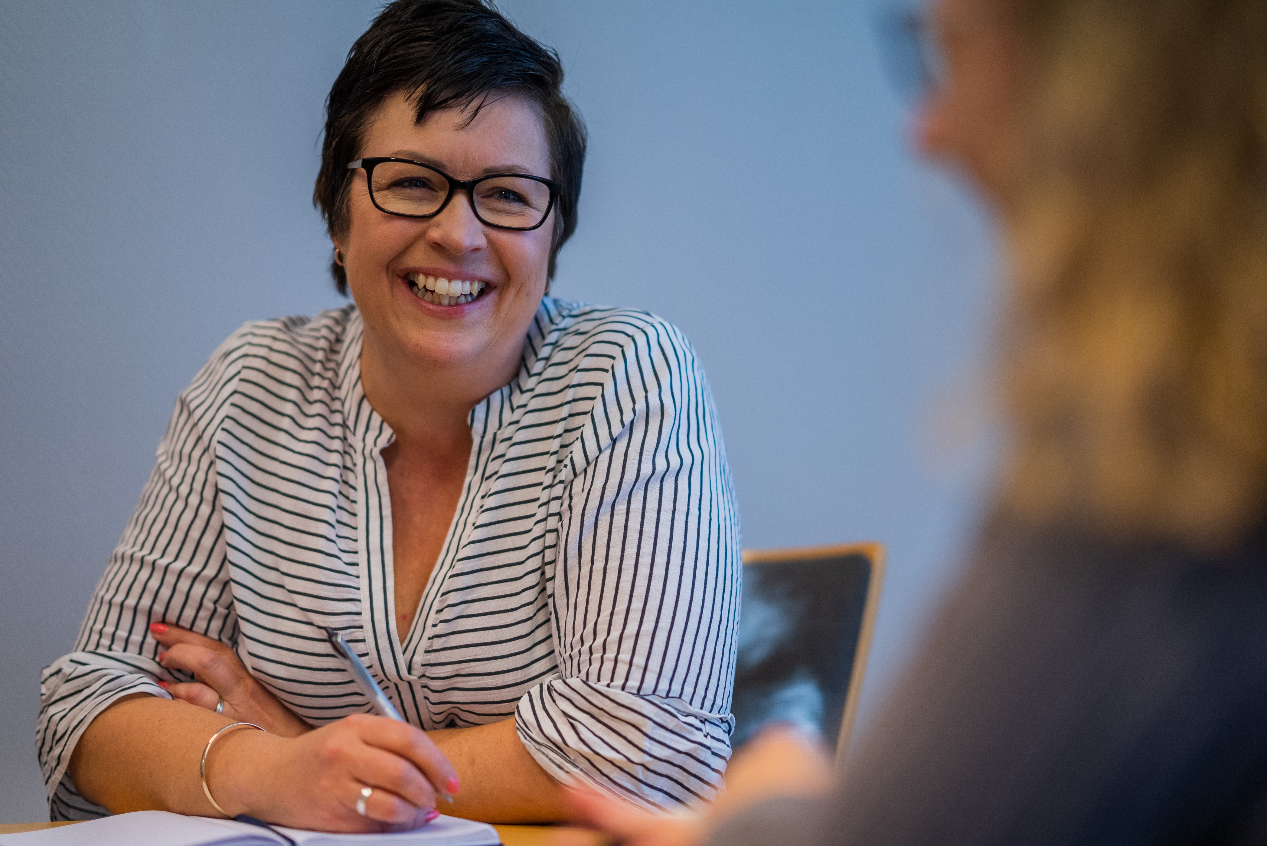 Illustrasjonsbilde. Viser en dame i dialog med en annen dame. Stemningen er tydelig god. Foto: Torstein Kiserud.