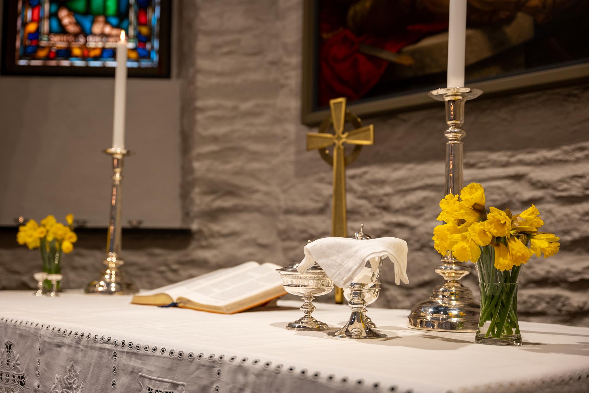 Bildet viser påskeliljer på et alter i en kirke. Foto: Terje Peersen