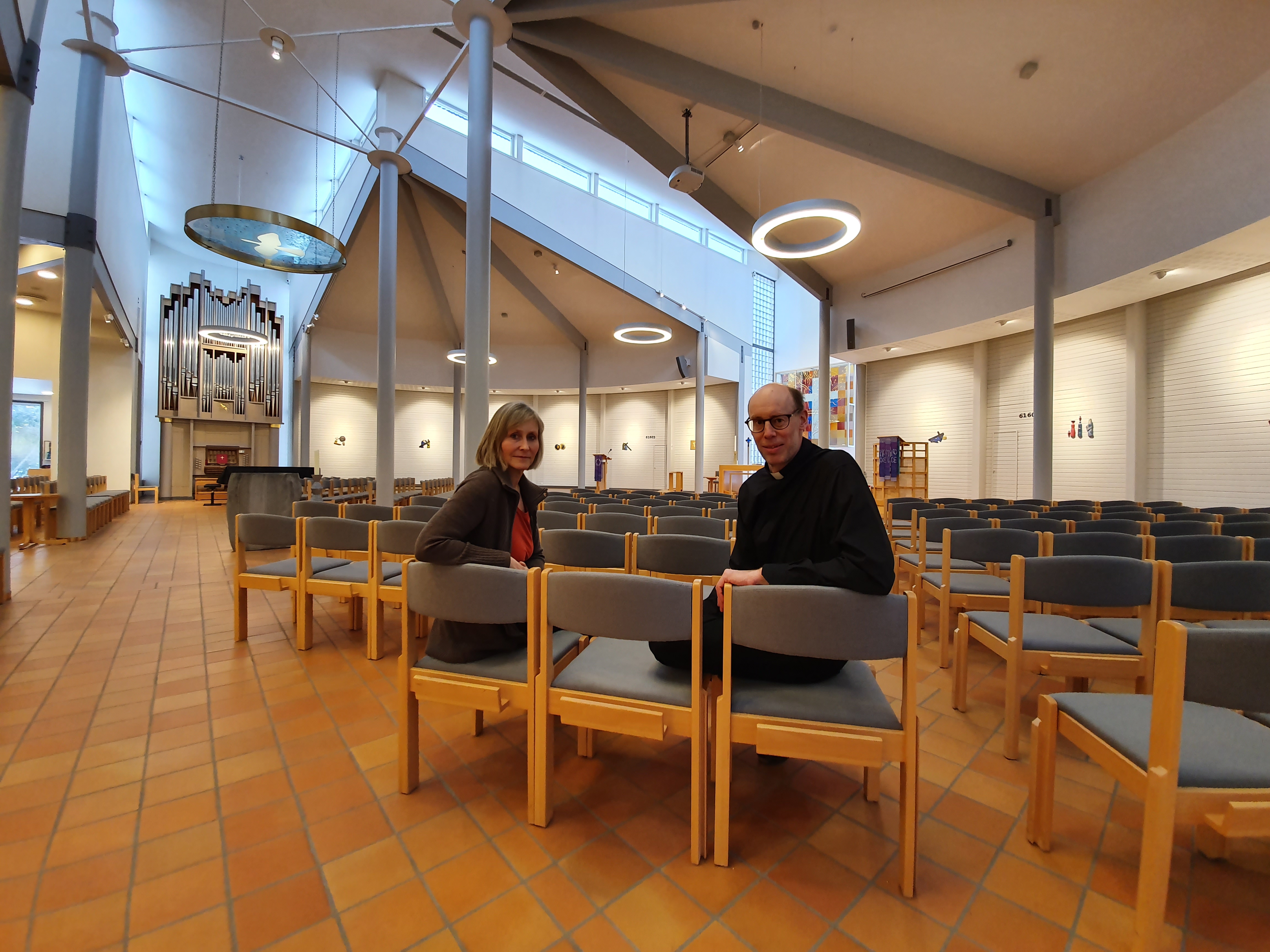 Diakon Vigdis larsen og sokneprest Torkel Irgens sitter på tomme kirkebenker.       Foto: Monica Nilsen