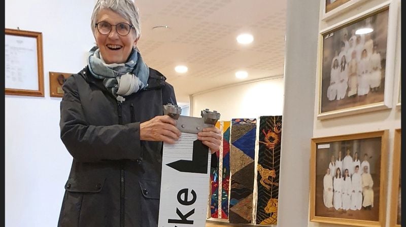 Foto: Monica Nilsen. Her kommer Anna Helene innom kirka med skiltet som viser vei til kirka. Den lå nede på bakken i Kirkeveien.