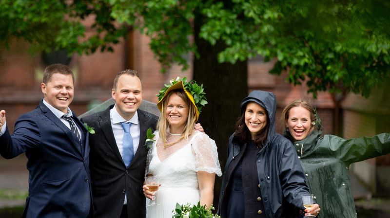 Nygift par med forlovere i regn. Foto: Kirkerådet/Bo Mathiesen