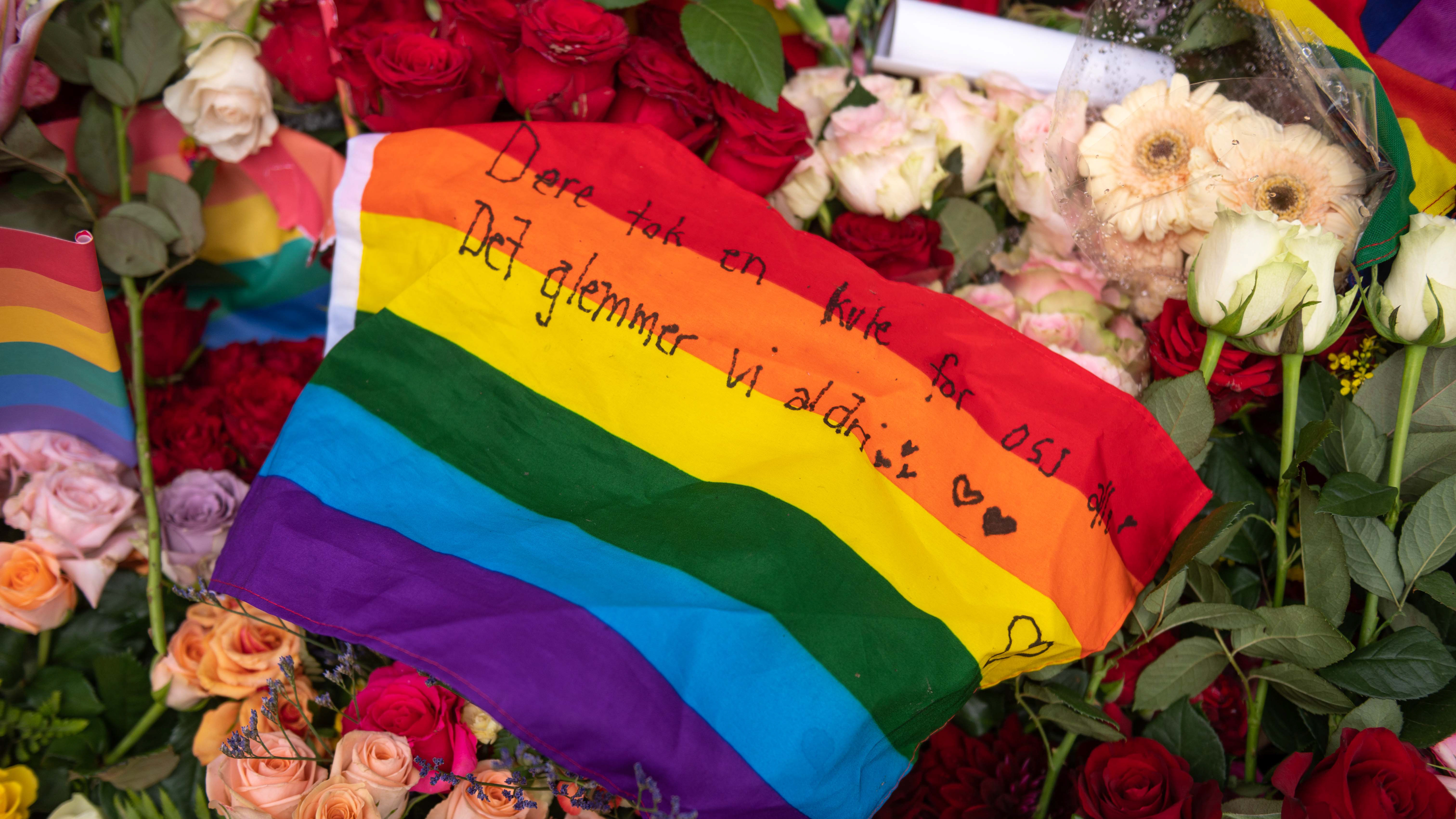Et Pride flagg med en sterk beskjed, lagt over blomsterhavet som oppsto etter 25. juni 2022 i Oslo. Foto: Ivar Barane