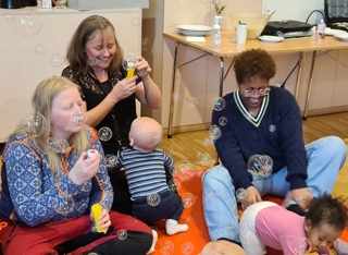 Bildet viser personer på babysang med såpebobler