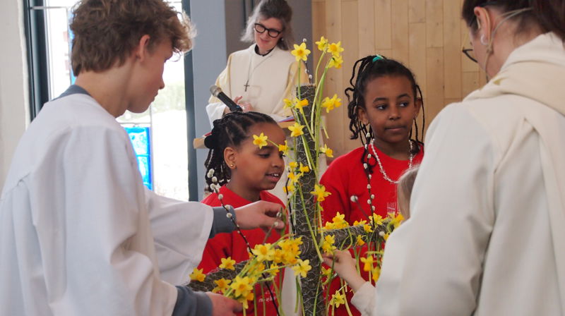 Fra barnas påskefest i Grymyr kirke 2024 med pynting av korset (foto Inger Stensrud Haug).