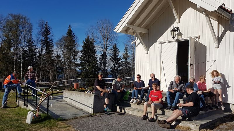 Dugnadsgjengen på Sørum kirkegård tok kaffen på kirketrappa i ettermiddagssola i mai i fjor (foto Bjoneroa menighetsråd).