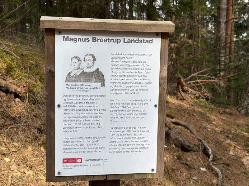 På vegen opp til Sølvsberget, finner du denne informasjonsplakaten til DnT Hadeland, som fortel om Landstad og om turen til Sølvsberget som magnus og Mina gjorde i 1826. Foto: Kirken i Gran/Inger S. Haug