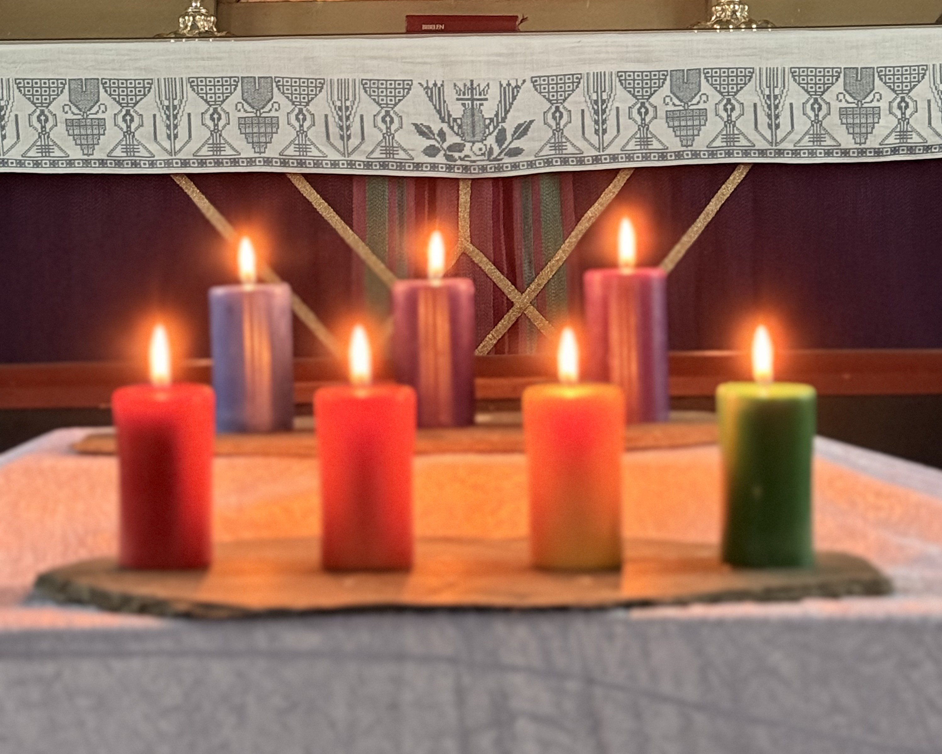 Regnbuelys foran altertavlen i Nes kirke. Foto: Eli-Kristin Sjøli Ulsund. 