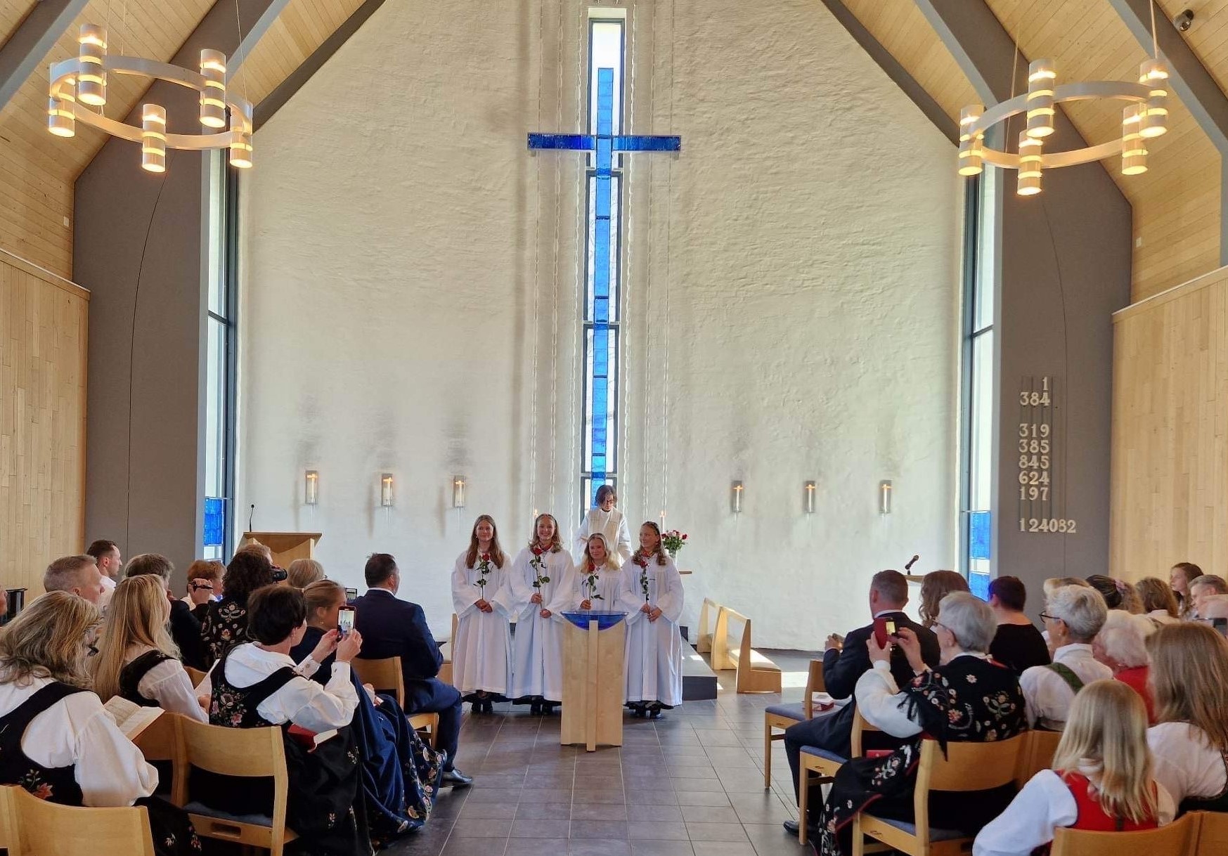 Konfirmasjon i Grymyr kirke med konfirmanter, prest Therese Wagle Bazard og festkledde gjester. Foto: Jan Myrvold. 