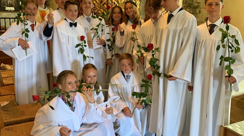 Konfirmantene får ofte overrakt en rose under konfirmasjonsgudstjenesten. Her er fjorårets konfirmanter i Nikolaikirken sammen med roser og sokneprest Therese Wagle Bazard (foto Kari Røken Alm).