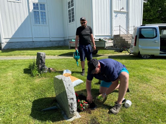 Her er kirketjenerne Morten og Ole Kristian i gang med planting på fondsgravene ved Nes kirkegård sommeren 2021. En oppgave blant mange for de allsidige kirketjenerne /kirkegårdsarbeiderne i Gran. (Foto: Inger S. Haug).