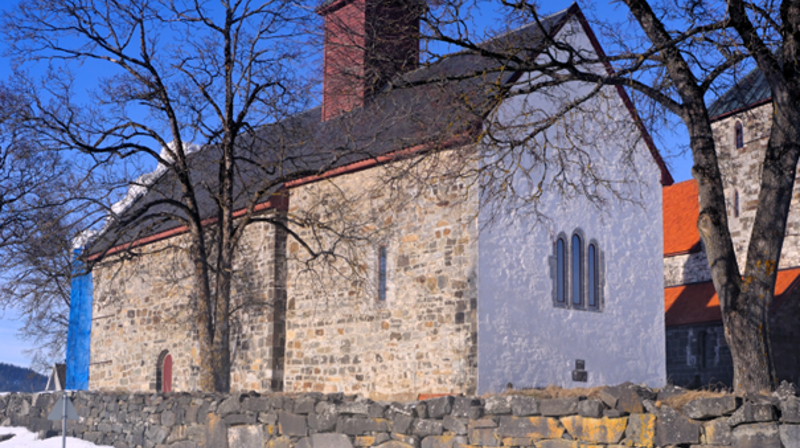 Mariakirken med hvitkalket østvegg og stillas på vestveggen. Nå er østveggen hvitkalket og stillaset satt opp mot sør for å ta siste veggen. I høst vil all sement i fugene være fjernet og erstattet med kalk og kirken være hvitkalket på nytt (foto: Morten Stige).