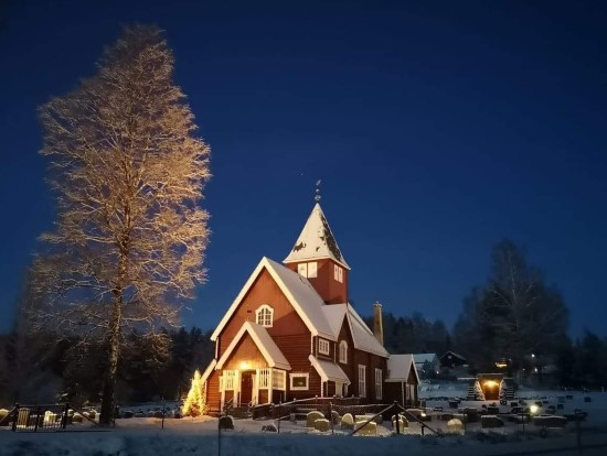 Moen kirke i nysnø og med juletreet tent, desember 2021. (Foto: Ruth Kari Sørumshagen). 