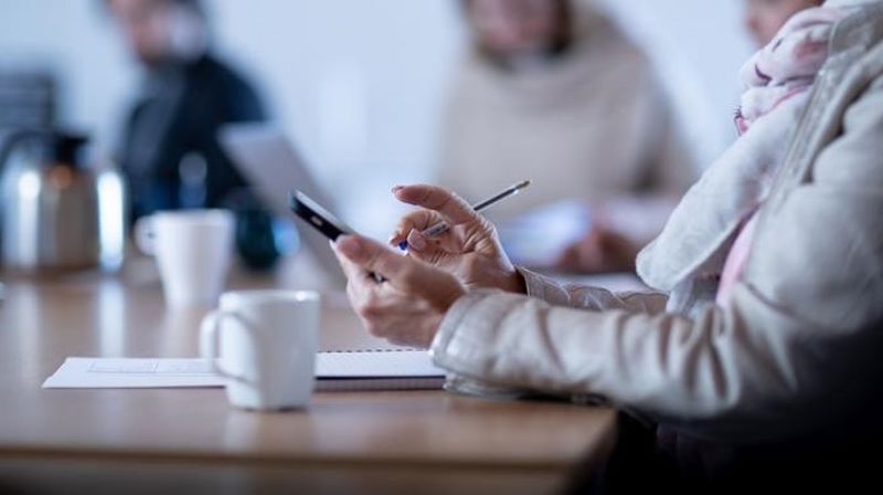 Dame holder smarttelefon i hånden