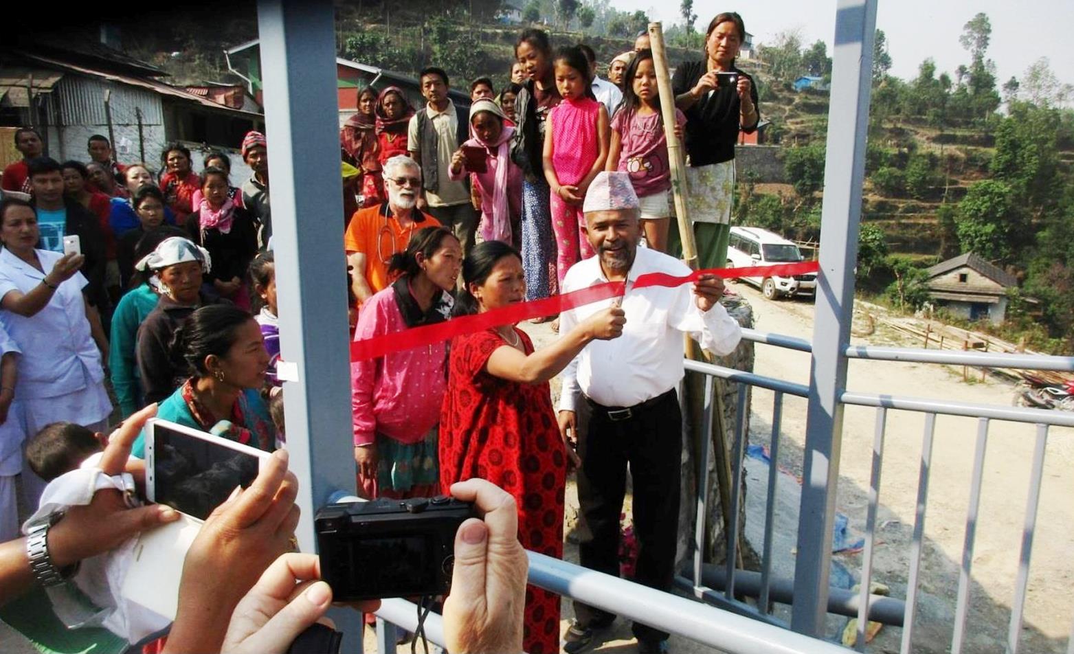 En av de mange gravide nær termin som bor på Mødreventehjemmet fikk æren av å klippe den røde snora, her med god hjelp av sykehusdirektør Tuk.