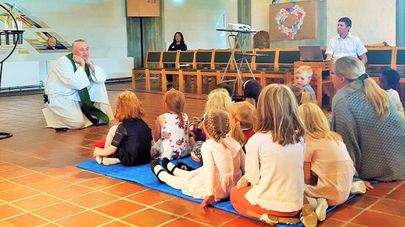 I Rossabø kirke har prest Bård Egil Dyrhold satt seg på gulvet for å fortelle om Martha og Maria til barna.
