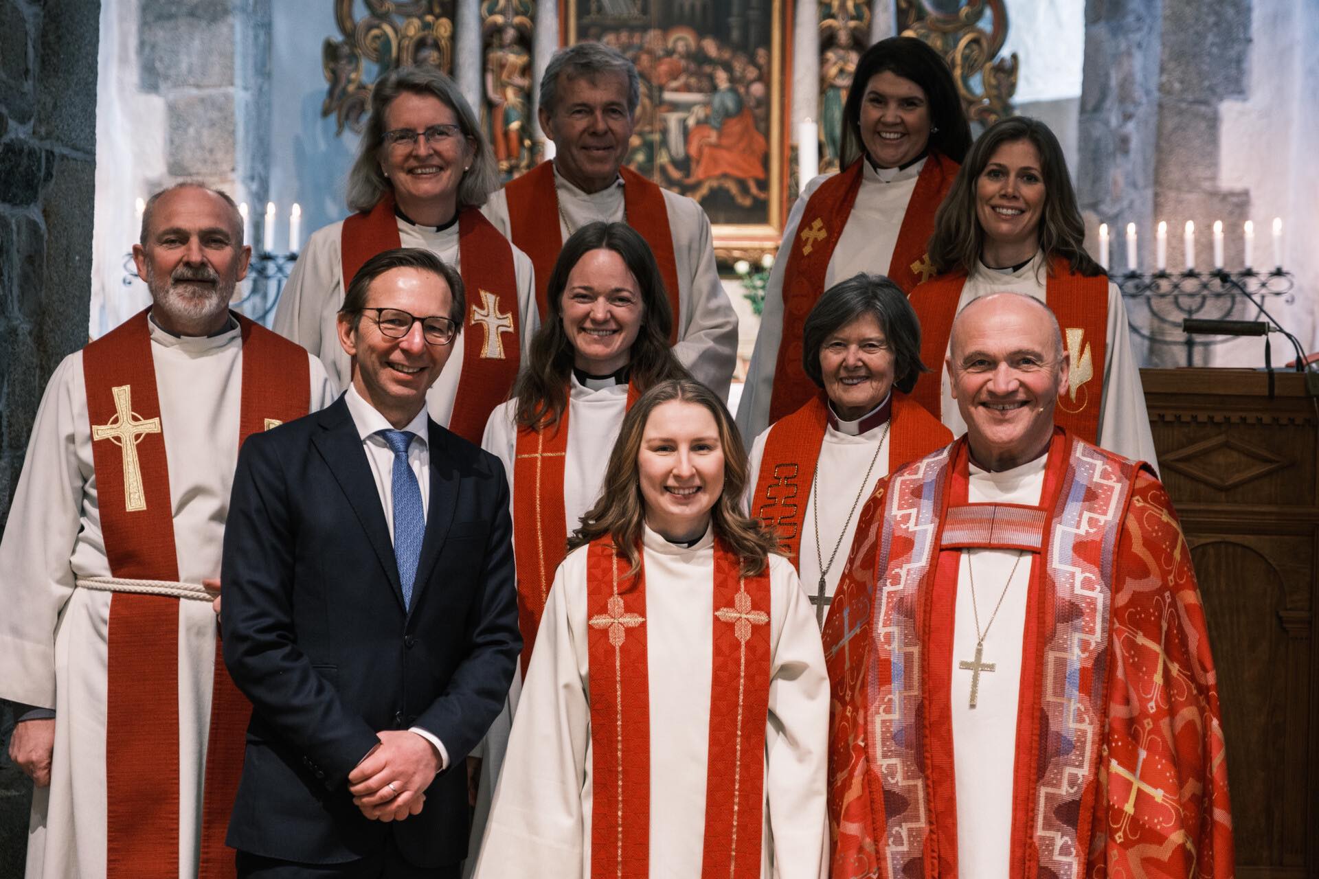 Ordinand Benedicte Gusland sammen med formann i Hedrum menighetsråd, Arvid Gusland, som også er Benedictes far. På Benedictes andre side står biskop i Tunsberg, Jan Otto Myrseth. I andre rekke står sokneprest i Hedrum, Thórir J. Thorsteinsson, fungerende sokneprest Matilde Opsahl og biskop emeritus Helga Haugland Byfuglien. I bakre rekke står prost i Larvik Sølvi Kristin Lewin, biskop emeritus Per Arne Dahl, sykehusprest Maria Lorentzen-Spydevold og sokneprest i Kvelde og Hvarnes Randi Abelsen Woldseth. Foto: Richard Fossland