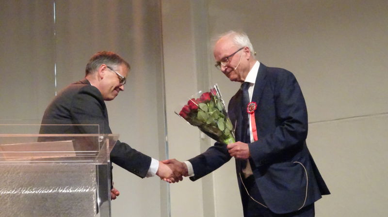 Møteleder Bernt Fløttum overrekker blomster til dagens hovedtaler, Åsmund Snøfugl