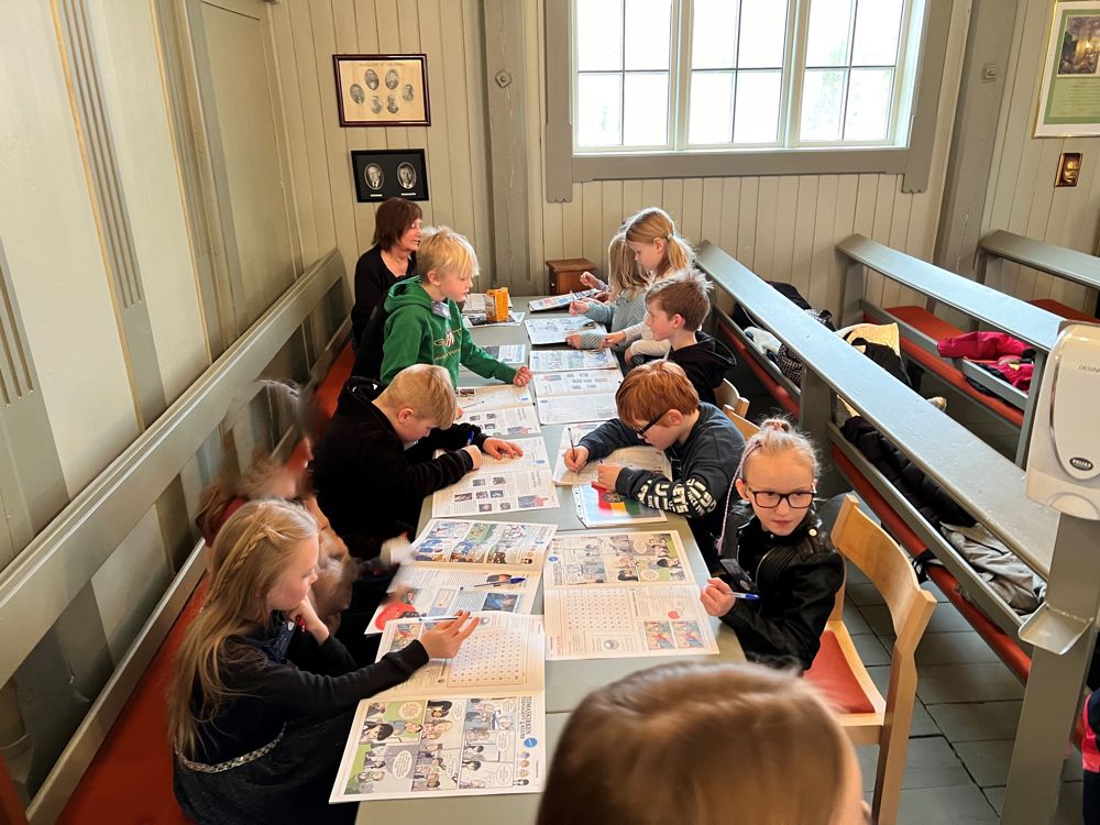 Tårnagentene sitter rundt et bord og jobber med agentavisa