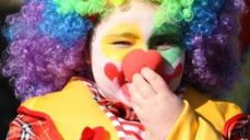 Bilde av et barn ukledd som klovn med fargerik parykk.