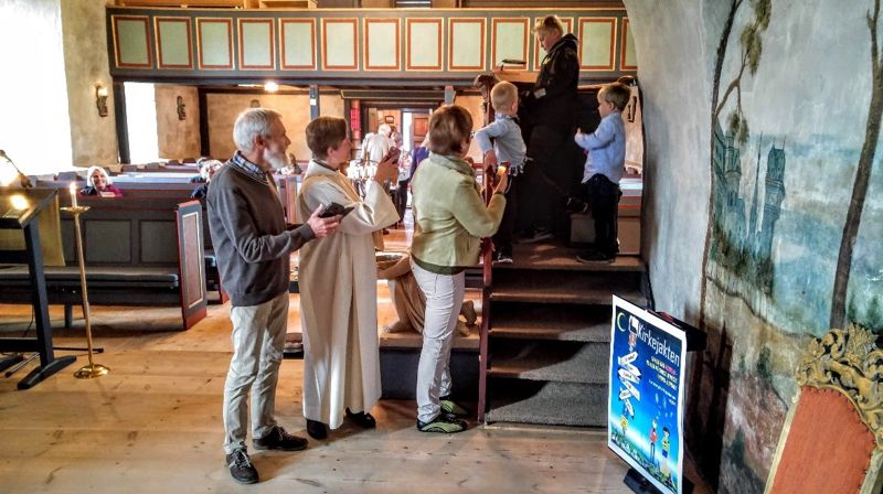 Folk i alle aldre med mobilen på kirkejakt i Ulnes kyrkje 17. juni 2018.