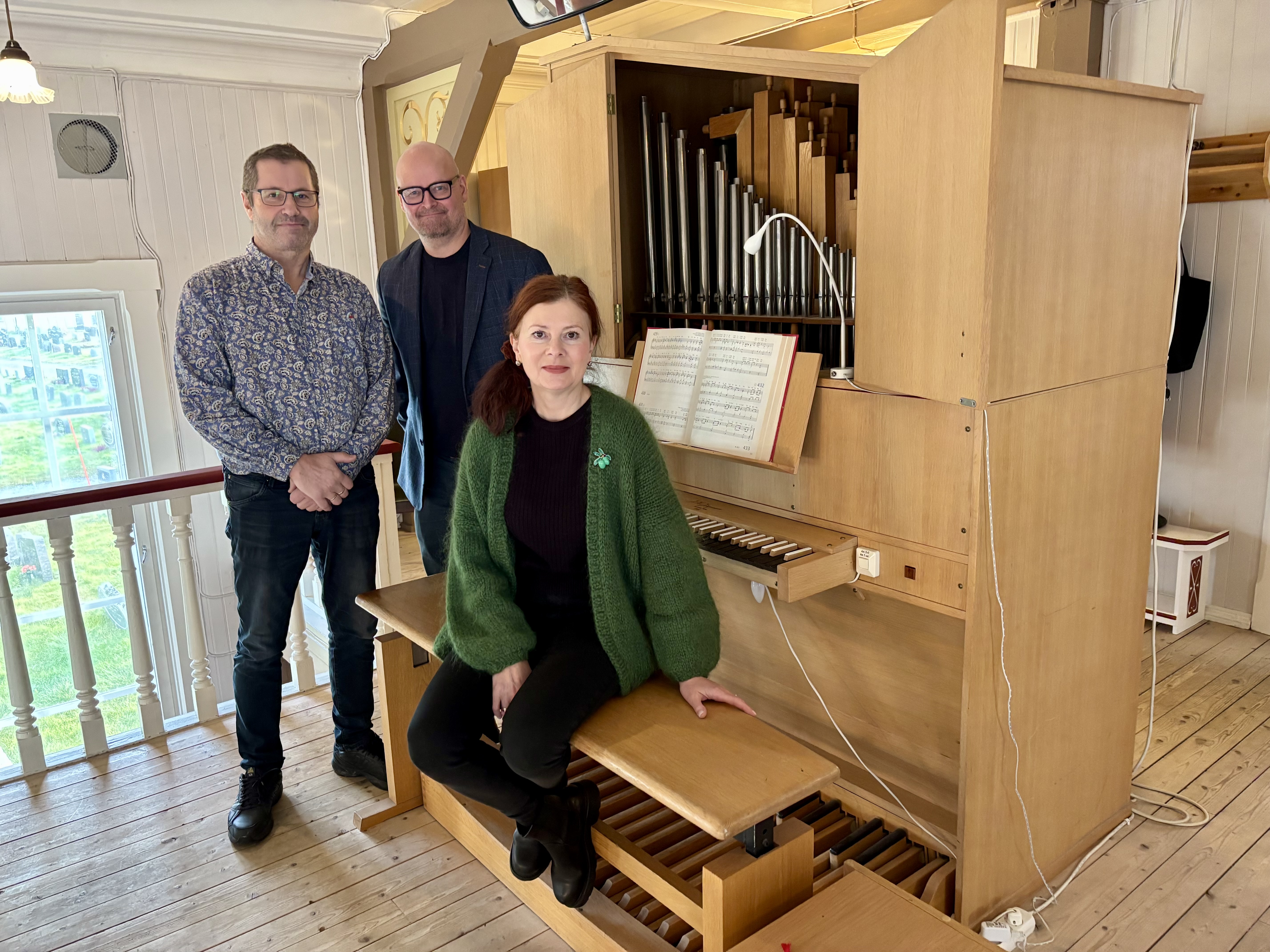 Fellesrådsleder Thorgeir Walsøe, sokneprest Onar Melnæs Haugli og organist Olga Jusupova-Nilsen gleder seg over at det gamle, midlertidige orgelet i Honningsvåg kirke, snart skal byttes ut med et nytt instrument