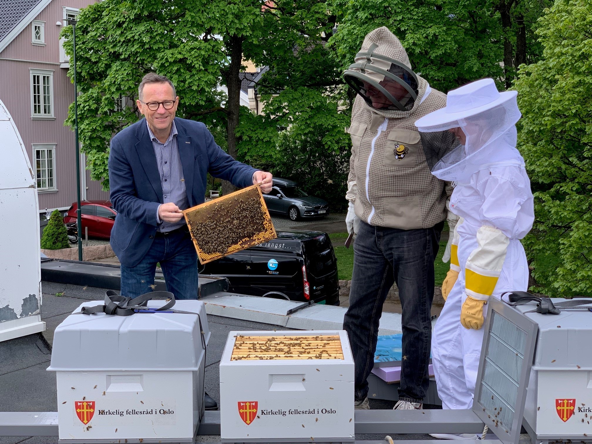 Kirkeverge Robert Wright, birøkter Erik Roede og lærling Renate Sæther steller godt med KfiO's nye leieboere i Akersbakken 32.