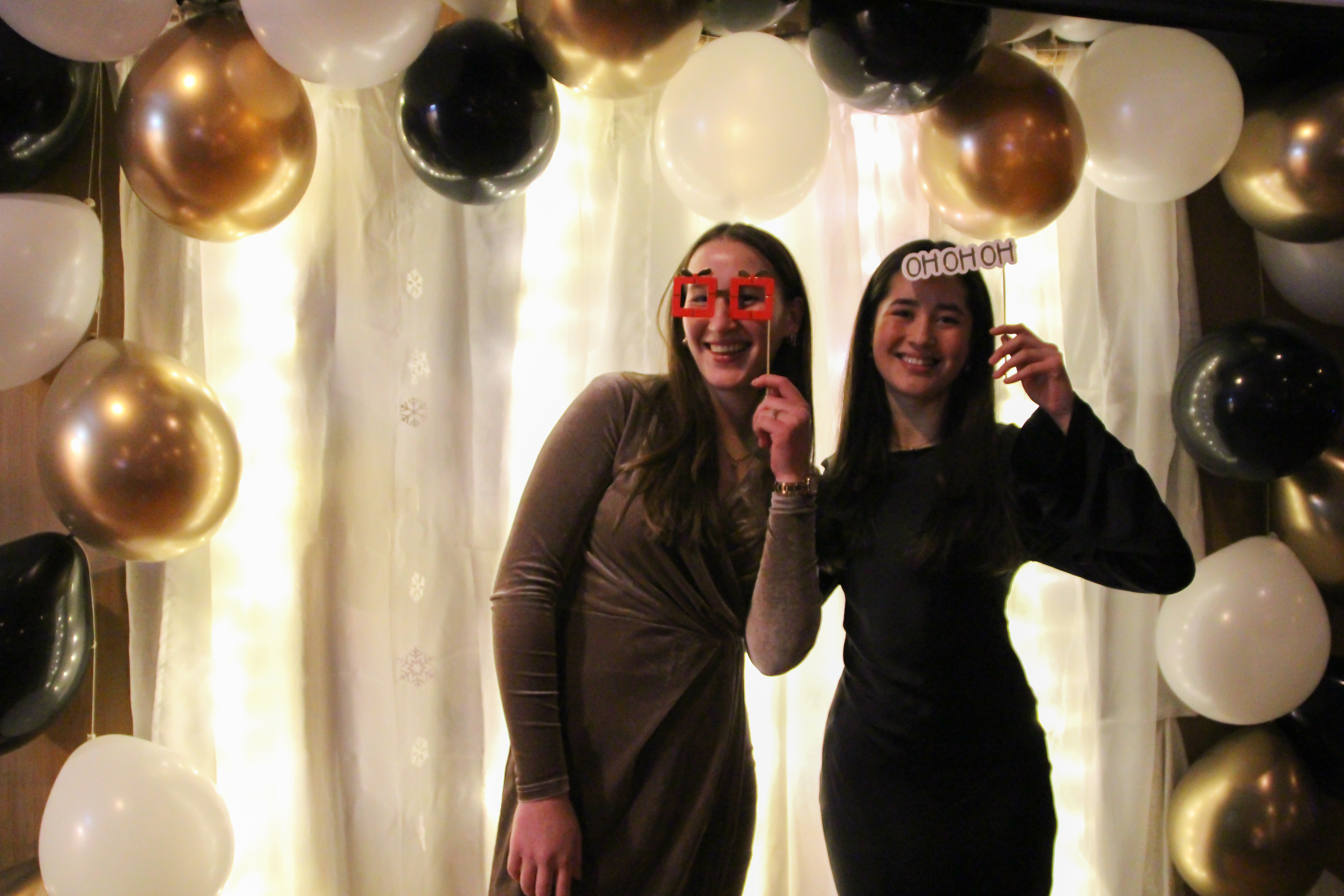 To festkledde jenter med festbriller og ballonger