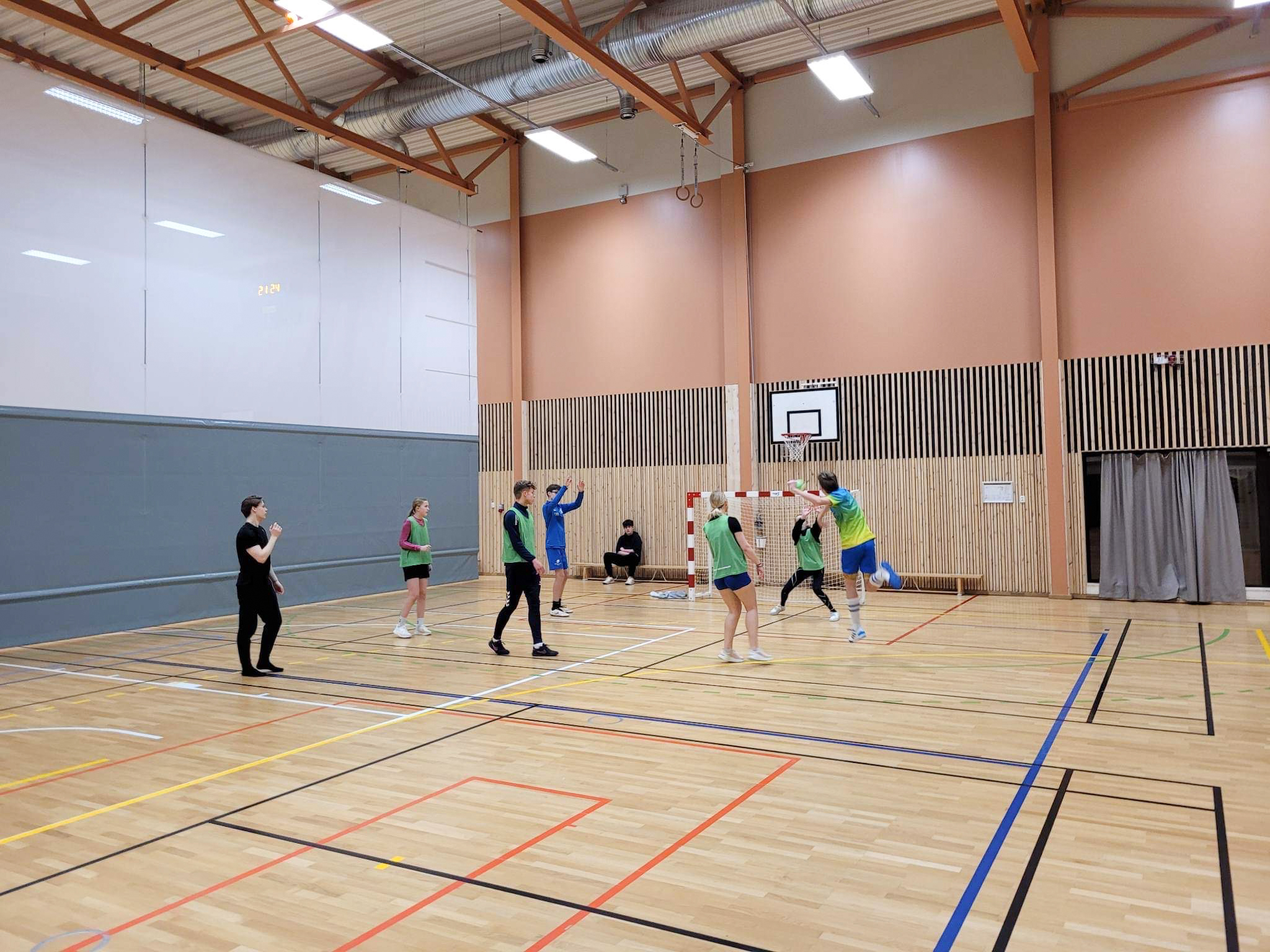 Ungdommer spiller håndball inne i en arena