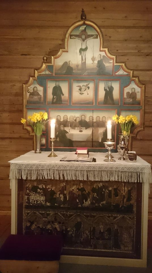 Alteret i Volbu kyrkje pynta med påskeliljer og bordet dekt for Jesu måltid Foto: Eli Vatn
