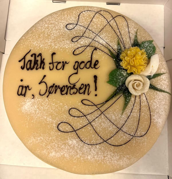 Rund kake med p&aring;skrift: Takk for gode &aring;r, S&oslash;rensen!
