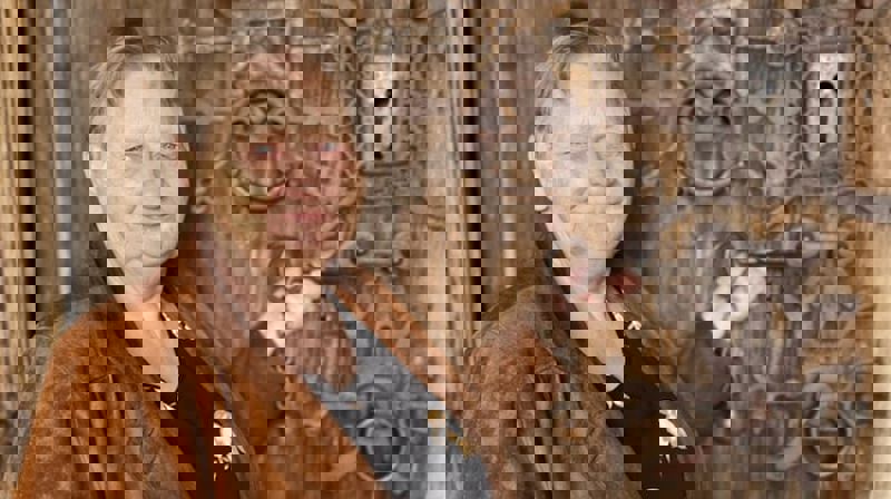 Mangeårig guide Marianne foran stavkirkedøra i Reinli