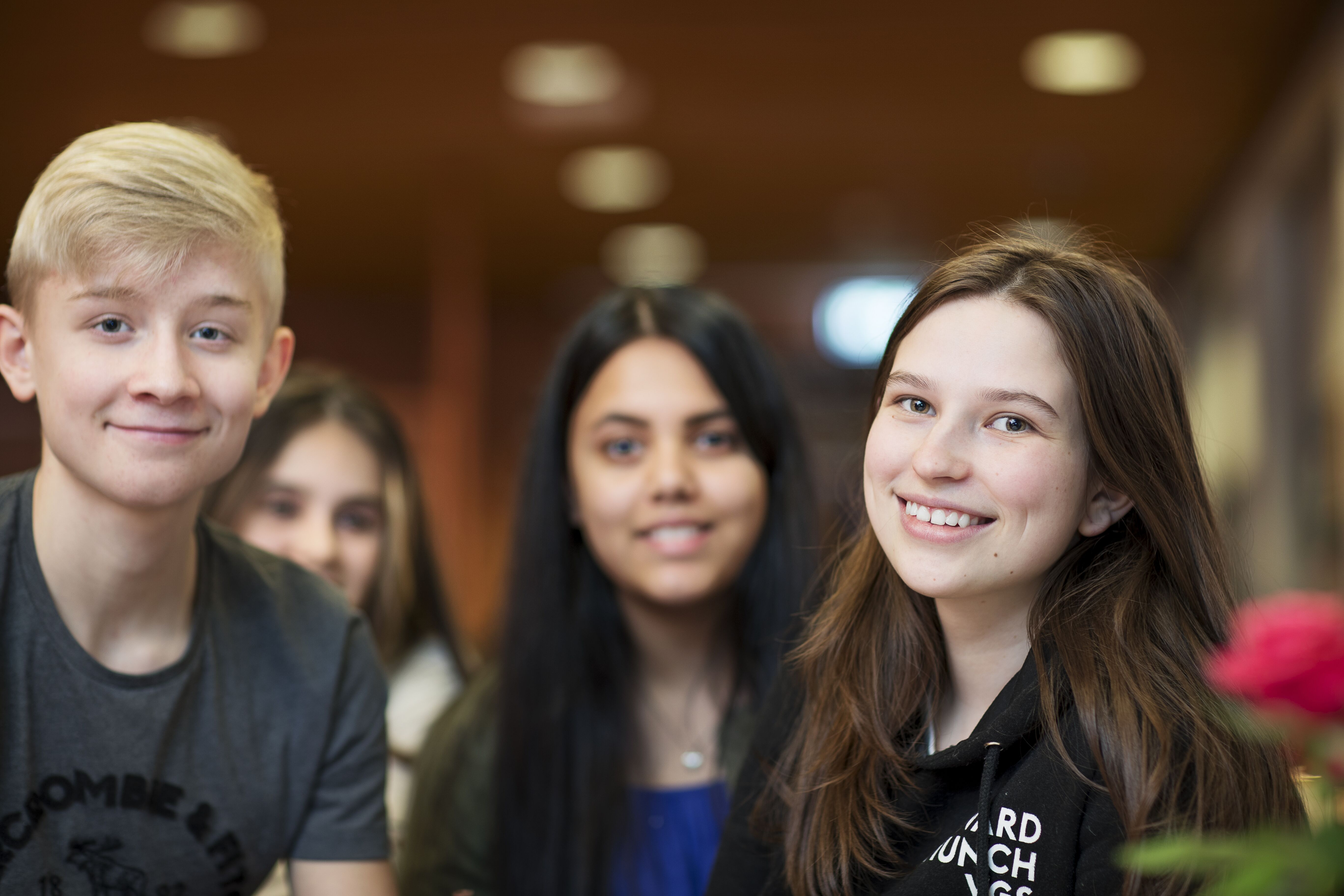 Fire ungdommer smiler vendt mot fotografen