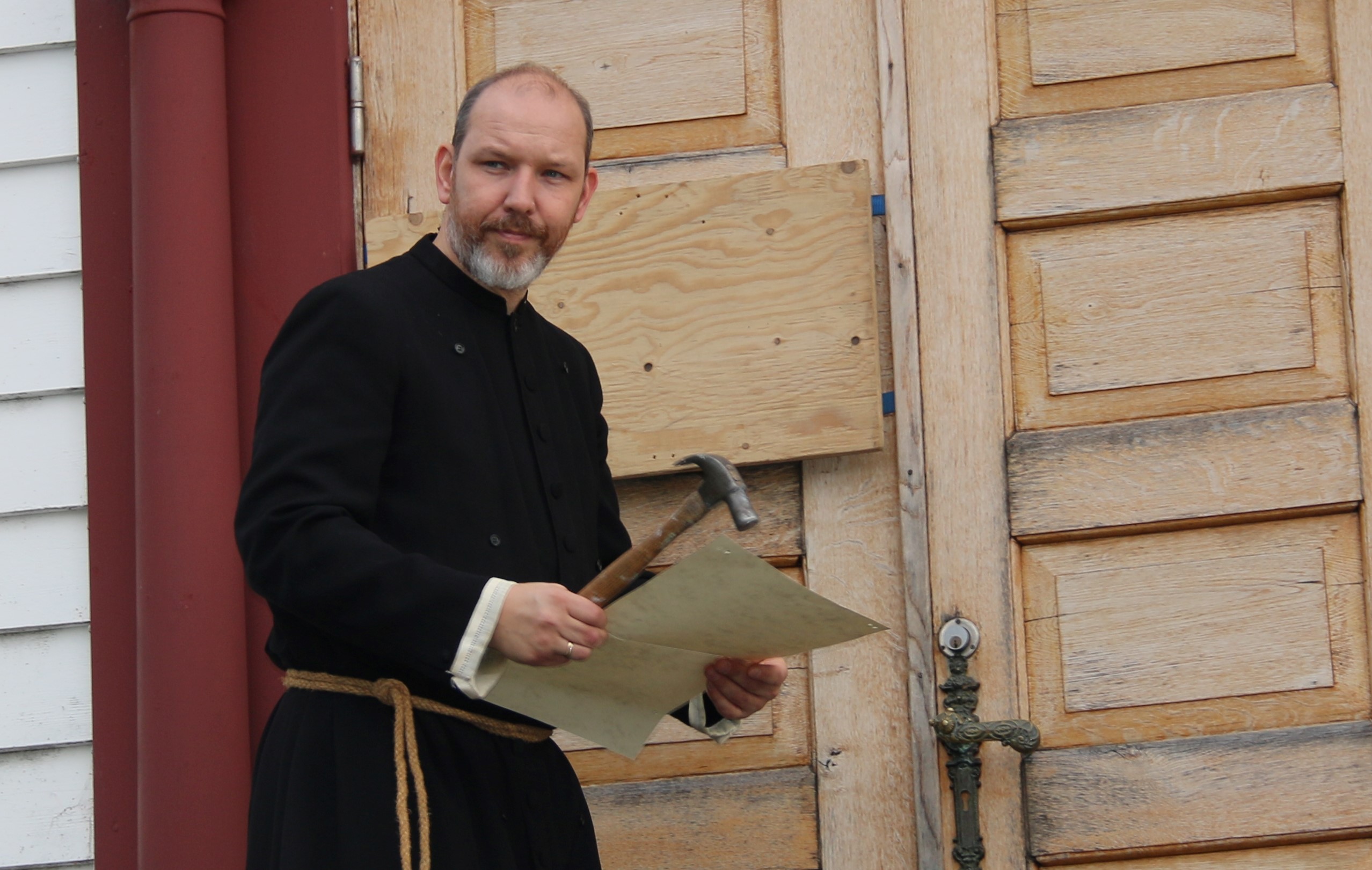 Martin Luther gjer seg klar til å spikre sine 95 teser på kyrkjedøra