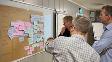 Hovedutvalgsmedlemmene Ann Kristin Langeland, Martin Enstad og Torbjørn Backer Hjorthaug i workshop med å plassere notatlapper med oppgaver og ansvar i en ny kirkelig struktur.