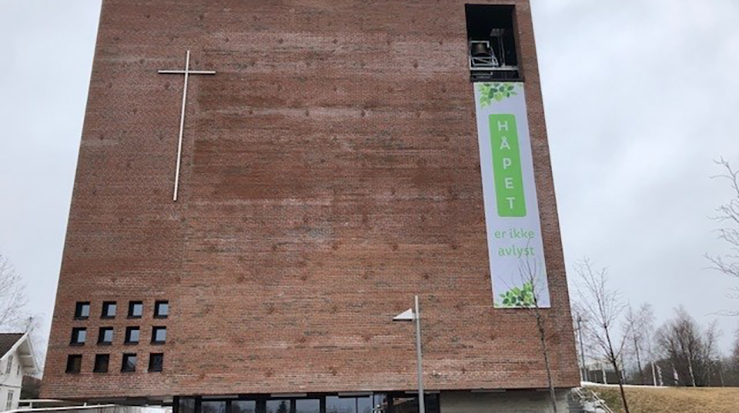 Kirketjener Øystein Mollestad får opp banneret i år. (Foto: Kristina Wallace)