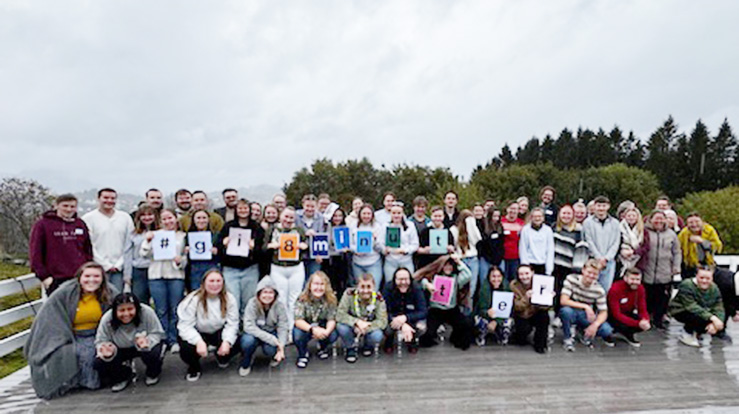 Årets UKM holder opp plakat #gi8minutter, som er oppfordringen i forbindelse med Verdensdagen for psykisk helse 8. oktober (Foto: Kirkerådet)