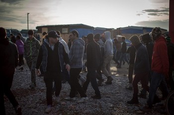 I det matutdelingen i den provisoriske flyktningleiren i Calais, Frankrike, tar slutt denne dagen i desember 2015, er det mange mennesker som må vende tilbake til teltet sitt tomhendt. Foto: Sean Hawkey/Kirkenes verdensråd